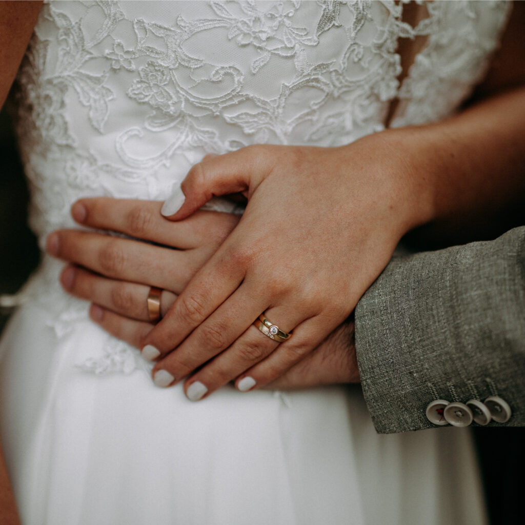 Hände von Hochzeitspaar mit Trauringen