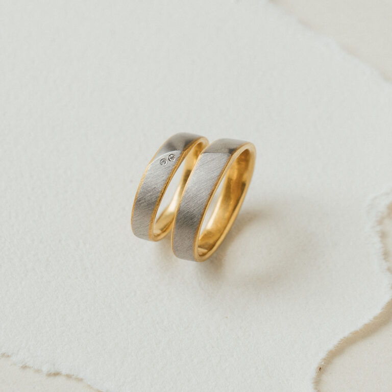 Besonderes Trauringpaar - bicolor, innen Gelbgold, außen in Platin gefertigt. Im Damenring Brillanten.