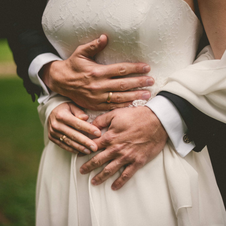 Brautpaar trägt ergonomische trauringe navettespalt band 750er rotgold navette-diamant strichmatt